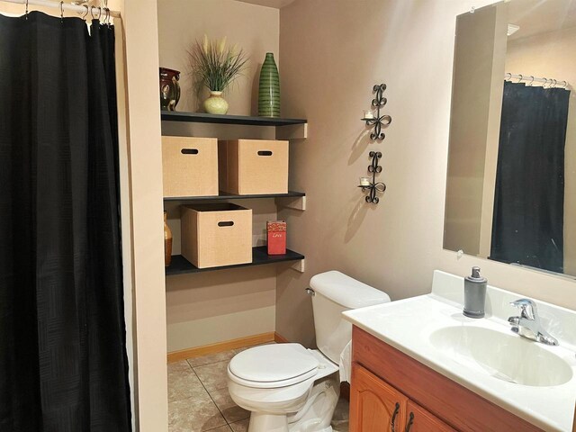 bathroom featuring vanity, tile patterned flooring, and toilet