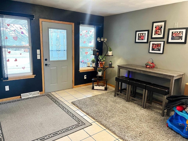 entryway featuring light tile patterned floors, visible vents, and baseboards