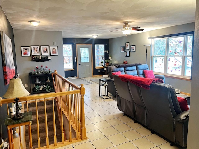 living area with a ceiling fan, baseboards, and light tile patterned floors