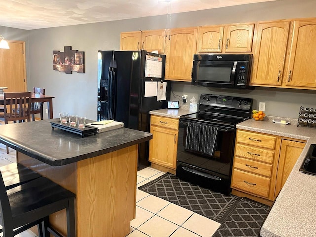 kitchen featuring a breakfast bar area, black appliances, and light brown cabinetry