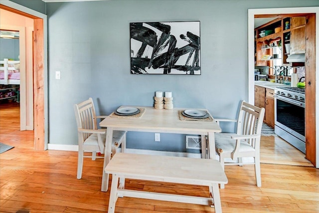 dining area featuring baseboards and light wood-style floors