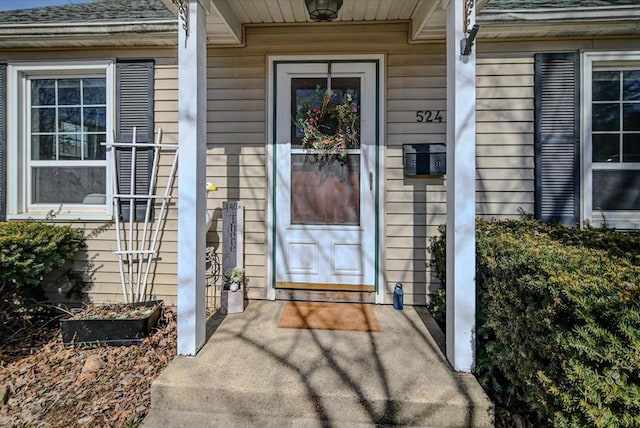 doorway to property featuring a shingled roof