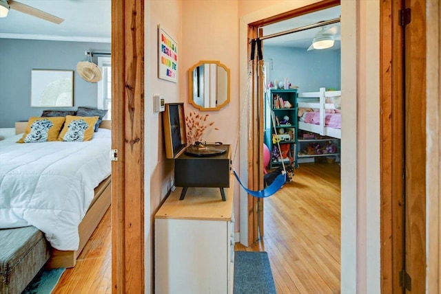 bedroom with wood finished floors and crown molding