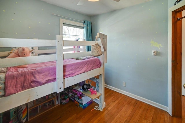 bedroom with baseboards, wood finished floors, and a ceiling fan