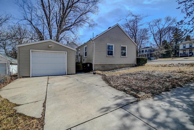 view of side of home with an outbuilding, a garage, and driveway