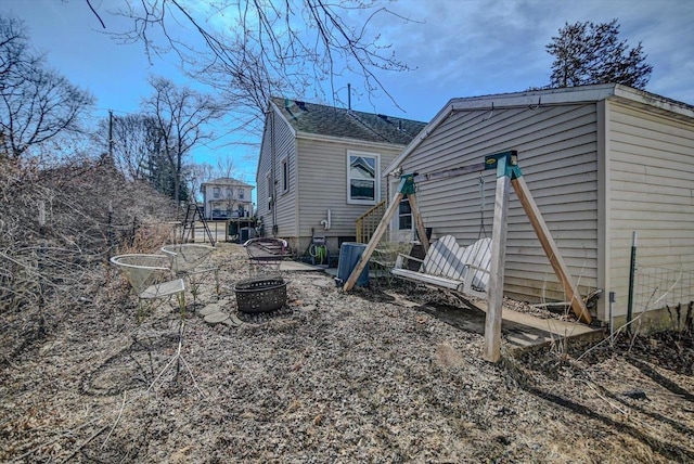 rear view of property featuring a fire pit