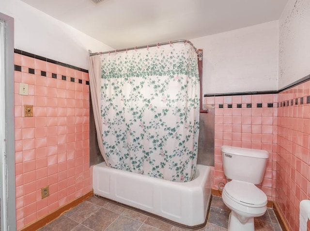 full bathroom featuring tile patterned flooring, shower / tub combo with curtain, tile walls, and toilet