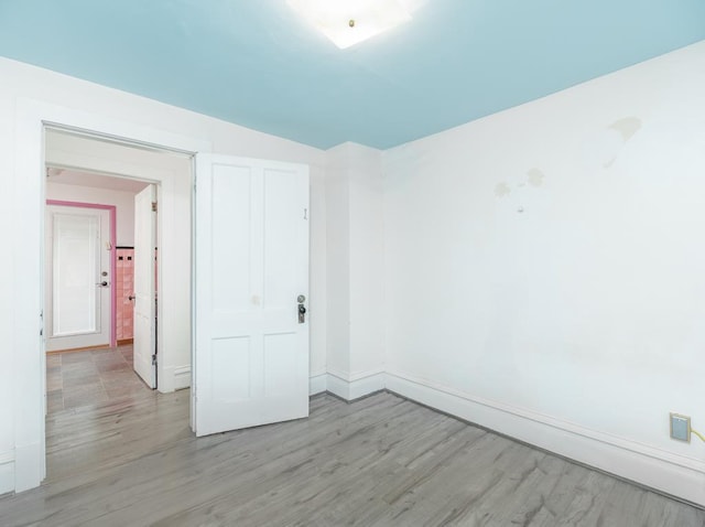 spare room with light wood-type flooring and baseboards