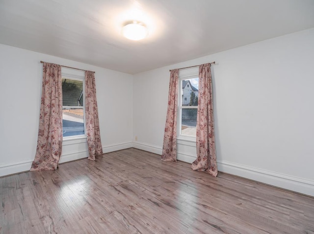 unfurnished room featuring baseboards and wood finished floors