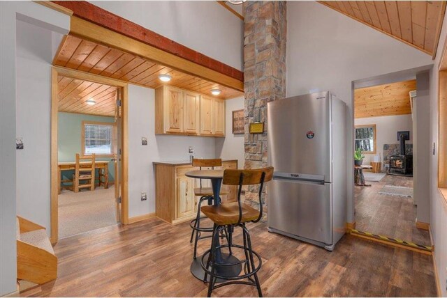 34239 Mcgraw Lake Rd, Danbury, WI 54830 - kitchen featuring wooden ceiling, beamed ceiling, freestanding refrigerator, a wood stove, and light brown cabinetry