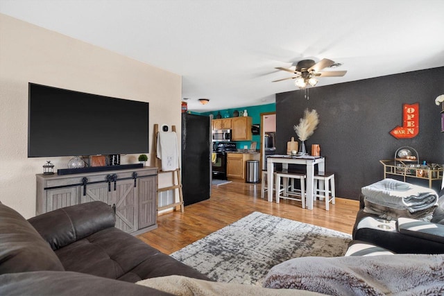 living area featuring a ceiling fan and light wood-style floors