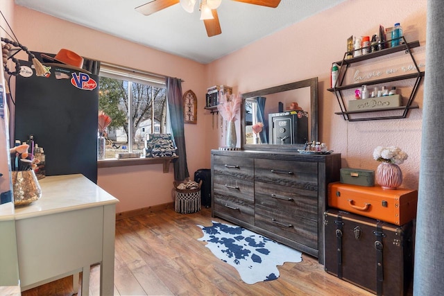 bedroom with light wood-style floors, baseboards, and a ceiling fan