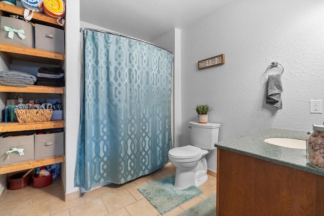 bathroom with a textured wall, toilet, tile patterned floors, vanity, and a shower with curtain