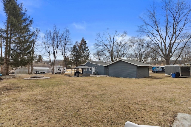 view of yard featuring an outdoor fire pit and fence