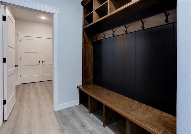 mudroom featuring light wood finished floors and baseboards