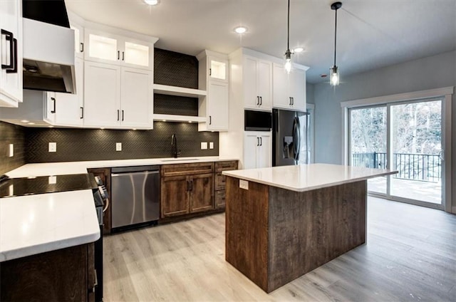 kitchen featuring a sink, refrigerator with ice dispenser, white cabinetry, light countertops, and stainless steel dishwasher