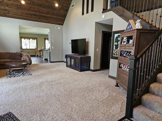 carpeted living area with stairs, high vaulted ceiling, visible vents, and baseboards