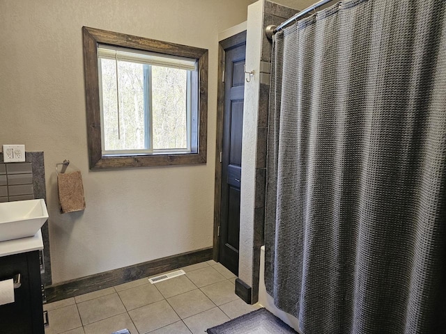 bathroom with visible vents, baseboards, a shower with shower curtain, tile patterned flooring, and vanity