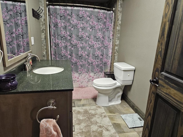 full bathroom with curtained shower, baseboards, vanity, and toilet