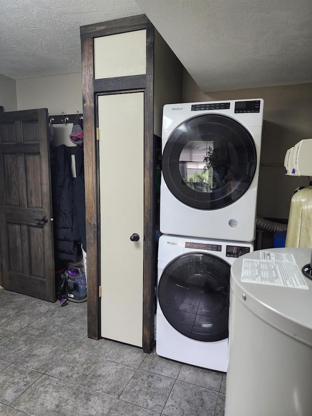 laundry room with stacked washing maching and dryer, laundry area, and a textured ceiling