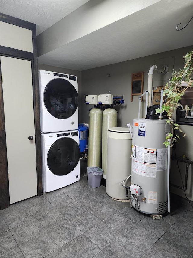 laundry room featuring stacked washer / drying machine, gas water heater, and laundry area