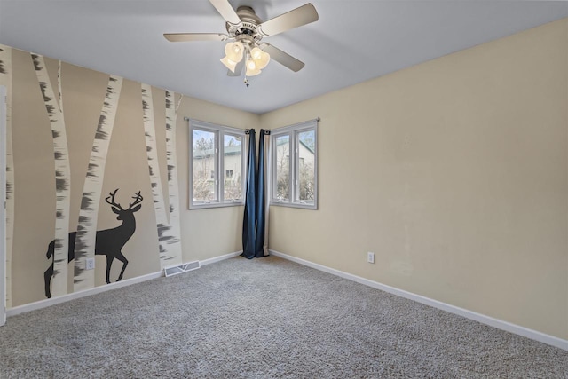 carpeted empty room with visible vents, ceiling fan, and baseboards