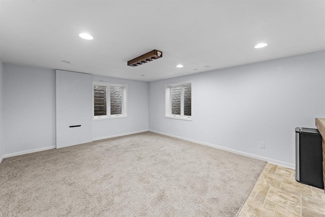 empty room with recessed lighting, stone finish floor, and baseboards