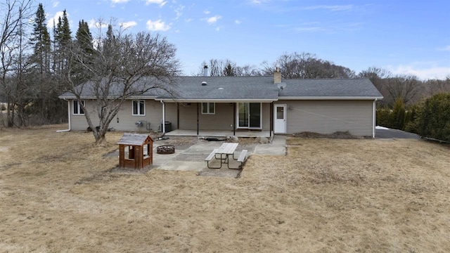 back of property featuring an outdoor fire pit, a chimney, a shingled roof, and a patio