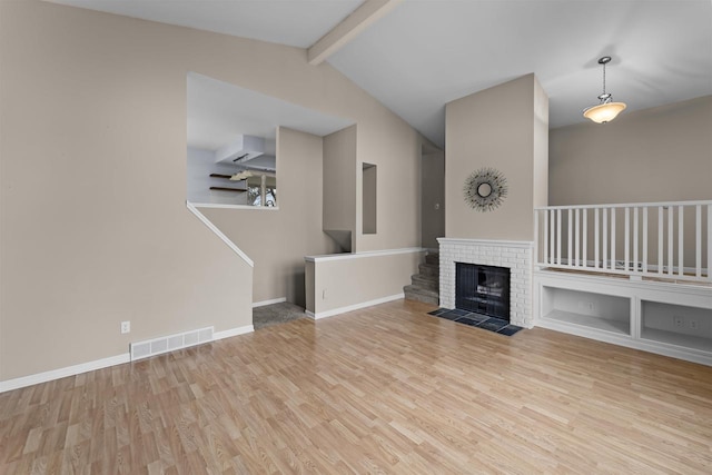 unfurnished living room featuring lofted ceiling with beams, wood finished floors, visible vents, and baseboards