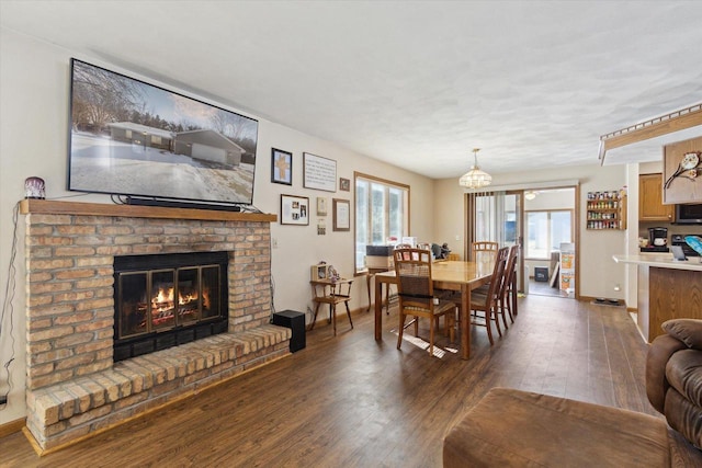 dining space featuring a fireplace, baseboards, and dark wood-style flooring