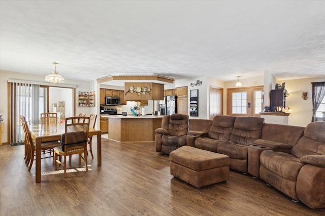 living area with an inviting chandelier and dark wood finished floors