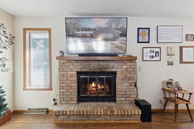 details with a brick fireplace, baseboards, and wood finished floors