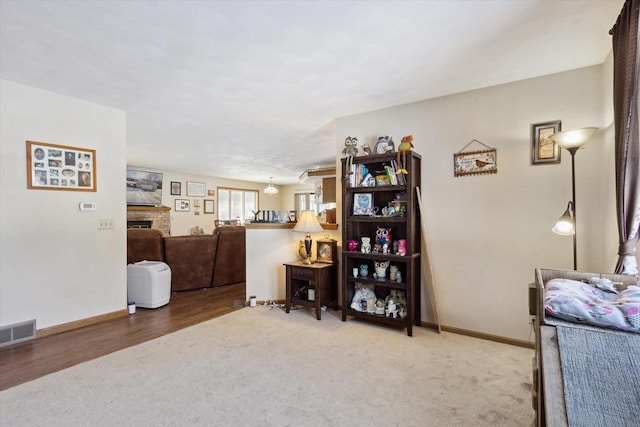 interior space with carpet floors, a brick fireplace, visible vents, and baseboards