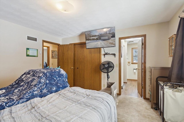 bedroom featuring light carpet, baseboards, visible vents, and a closet