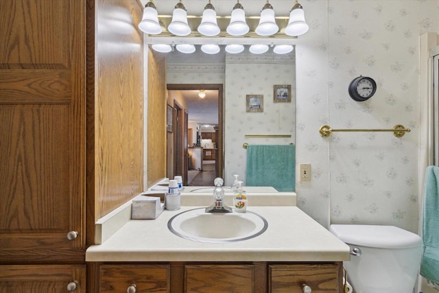 bathroom featuring ensuite bathroom, vanity, toilet, and wallpapered walls