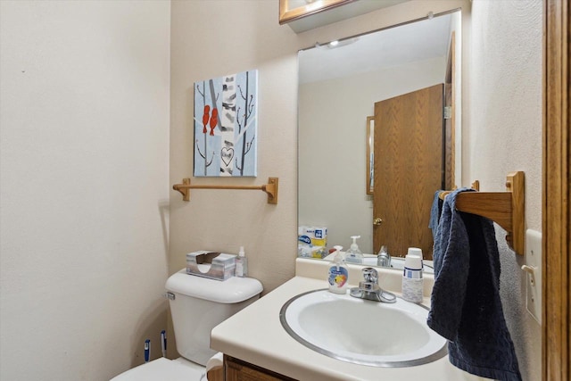 half bathroom with vanity and toilet