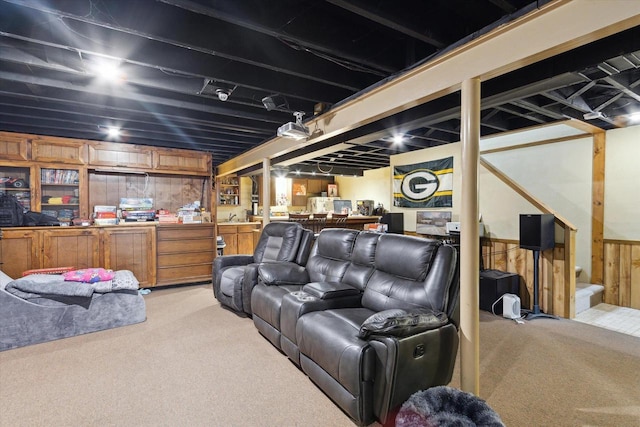 home theater room featuring light carpet and wooden walls