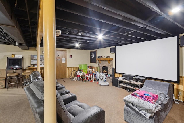 home theater room with carpet, wainscoting, a fireplace, and wooden walls