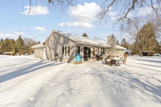 rear view of property featuring a chimney and a sunroom