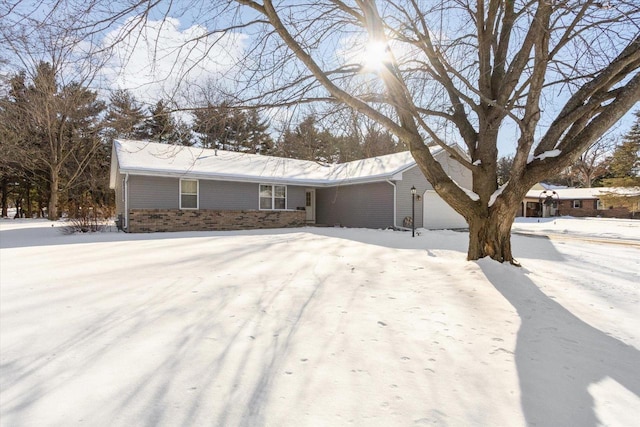 single story home featuring an attached garage and brick siding