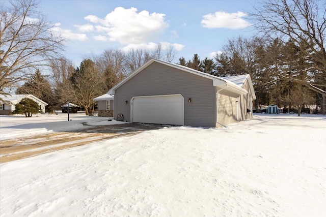 snow covered property featuring an attached garage