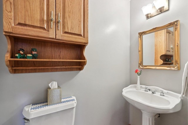 half bath featuring toilet and a sink