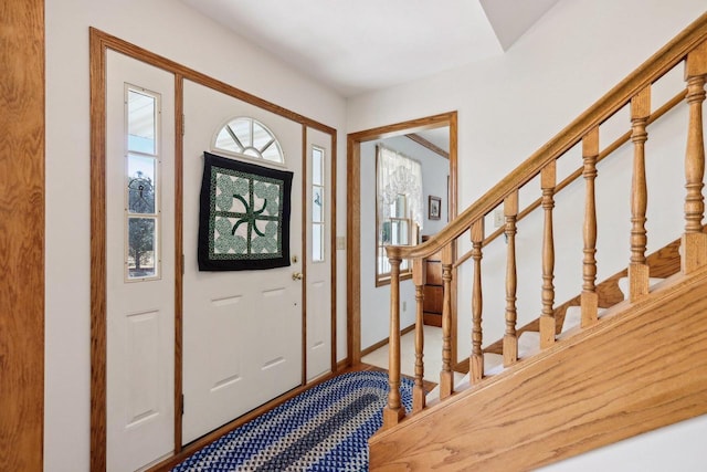 foyer with stairway and baseboards