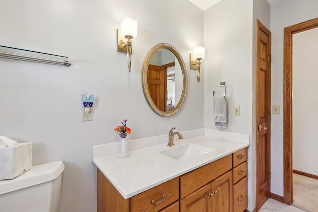 bathroom with vanity, toilet, and baseboards