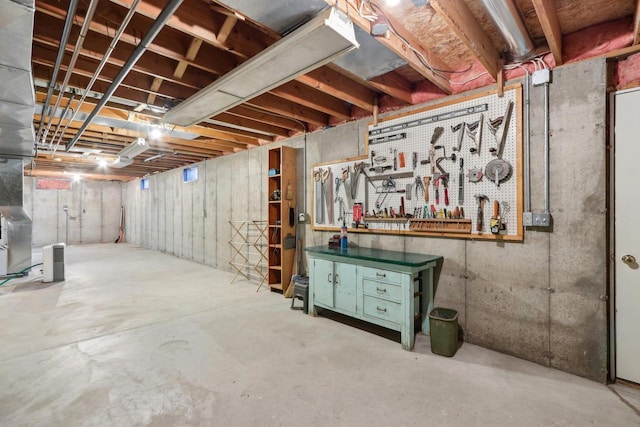 unfinished basement featuring a workshop area