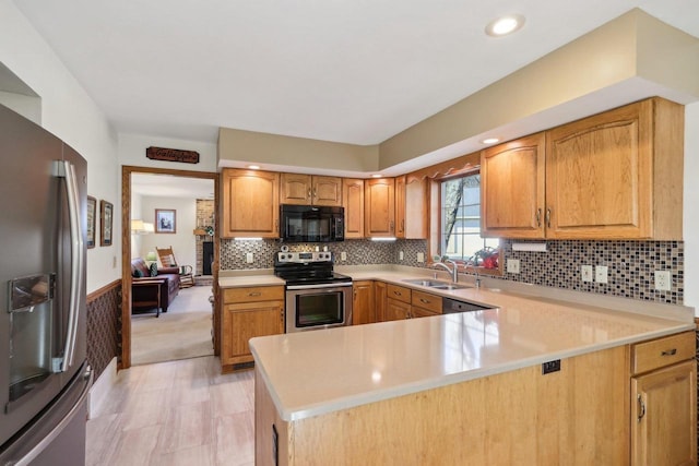 kitchen featuring stainless steel appliances, backsplash, a sink, and light countertops