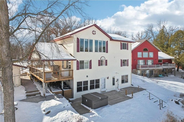 snow covered rear of property with a wooden deck