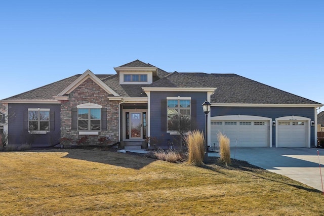 view of front of property featuring a garage, concrete driveway, stone siding, and a front yard