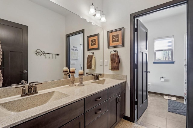 full bathroom featuring double vanity, tile patterned flooring, a sink, and toilet