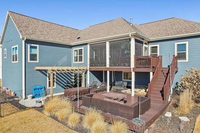 rear view of house with a shingled roof, stairway, a sunroom, fence, and a deck